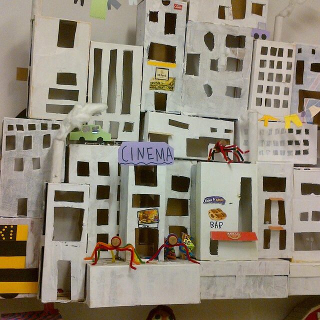 Maqueta d'una ciutat construïda amb capses de cartró, amb un cinema i gratacels