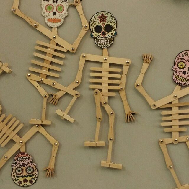 Esquelets articulats de fusta amb calaveres mexicanes decorades